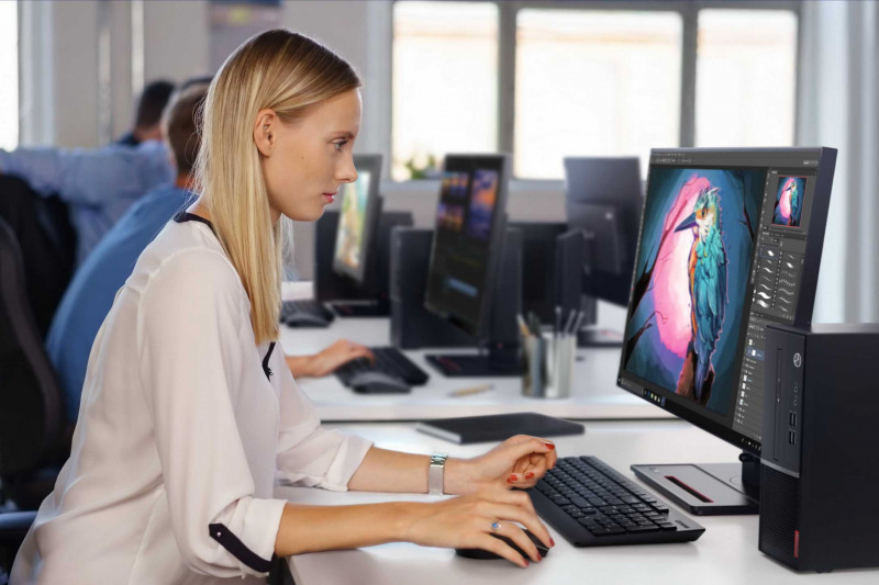 Ein Lenovo Campus Monitor steht vor einer Studentin, die auf der Tastatur tippt. Nur ihre Hände sind sichtbar, während sie konzentriert arbeitet. Die Szene vermittelt eine ruhige, fokussierte Arbeitsatmosphäre.